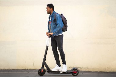 Tüm vücut portresi mutlu Afrikalı Amerikalı adam Mobile Scooter 'la caddede