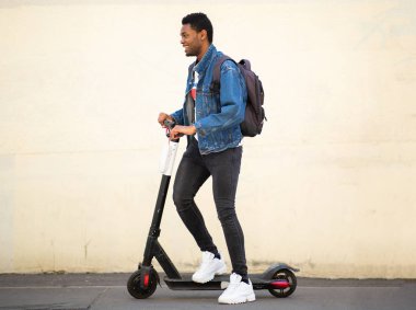 Tüm vücut portresi mutlu Afrikalı Amerikalı adam Mobile Scooter 'la caddede
