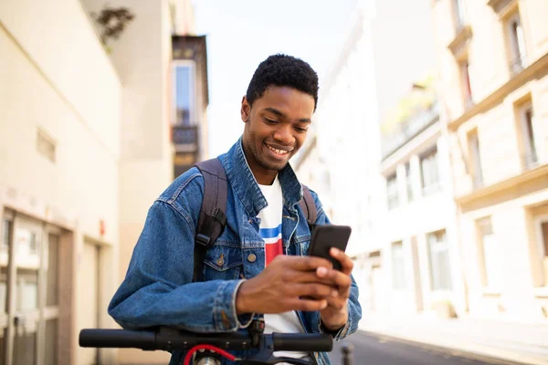 都市の携帯電話を見てクールなアフリカ系アメリカ人の若者の肖像画 — ストック写真