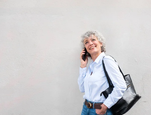 Beyaz Duvara Yaslanırken Cep Telefonuyla Konuşan Orta Yaşlı Kadının Yan — Stok fotoğraf