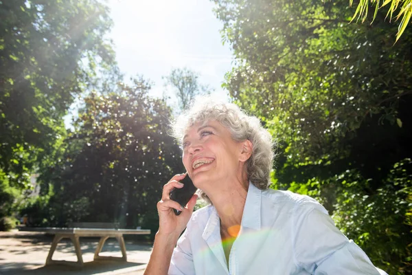 Porträtt Lycklig Äldre Kvinna Sitter Parken Talar Med Mobiltelefon — Stockfoto