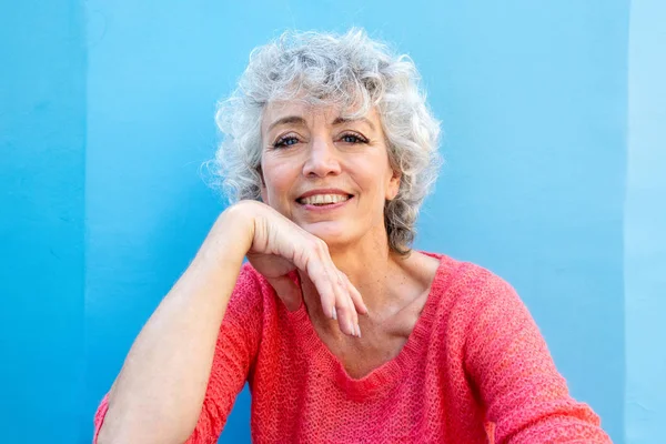 Çekici Gülümseyen Orta Yaşlı Bir Kadının Mavi Duvardaki Portresini Kapat — Stok fotoğraf