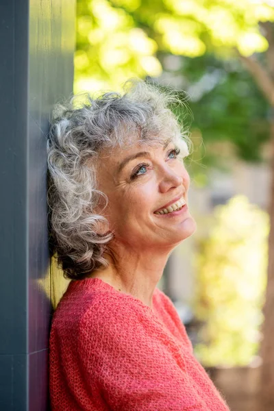 Πλευρικό Πορτρέτο Της Ελκυστική Ηλικιωμένη Γυναίκα Ακουμπά Στον Τοίχο Χαμογελώντας — Φωτογραφία Αρχείου