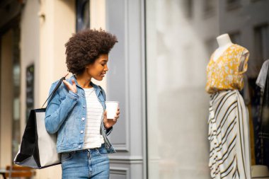 Modern Afro-Amerikan kadın portresi sokak vitrinlerinde yürüyor.