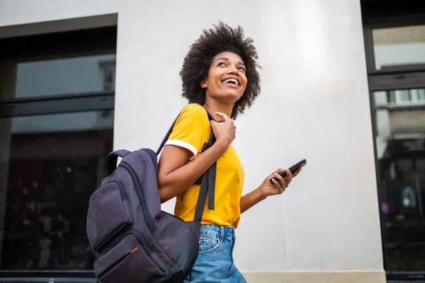 Dışarıda Cep Telefonu Çantasıyla Dolaşan Mutlu Siyah Bir Kadının Yan — Stok fotoğraf