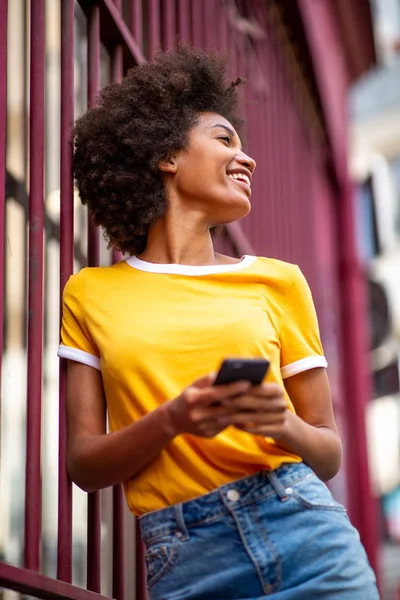 Portrait of beautiful african american woman laughing with cellphone