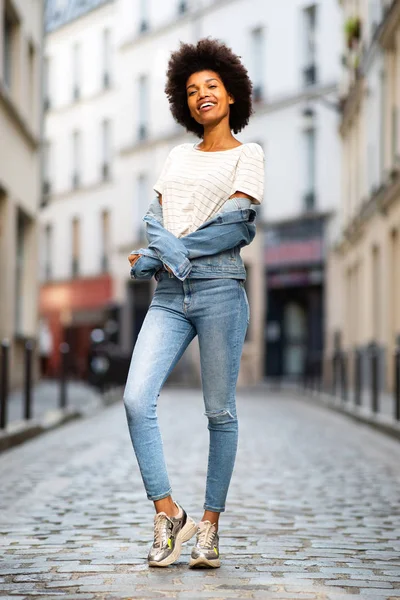 全身肖像画の笑顔若いアフリカ系アメリカ人女性ファッションモデル立って路上で街デニムジャケット — ストック写真