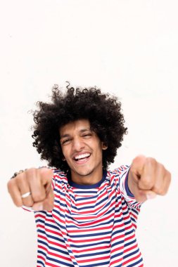 Afro saçlı, gülümseyen ve parmaklarını beyaz arka planda gösteren havalı genç Arap 'ın portresi.