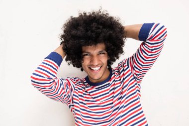 Beyaz arka planda elleri başının arkasında mutlu genç bir Arap 'ın portresini yakından çek.