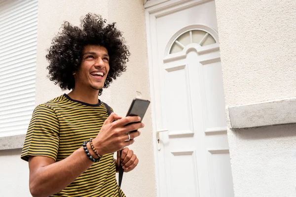 幸せな若いです男保持携帯電話の肖像画と外を歩く — ストック写真