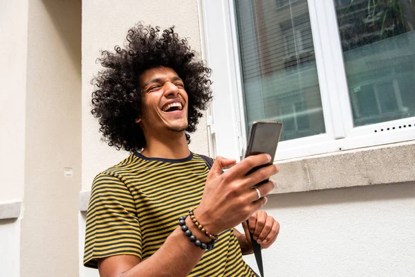 Close Portret Szczęśliwego Młodego Człowieka Afro Włosy Śmiejąc Się Telefonu — Zdjęcie stockowe