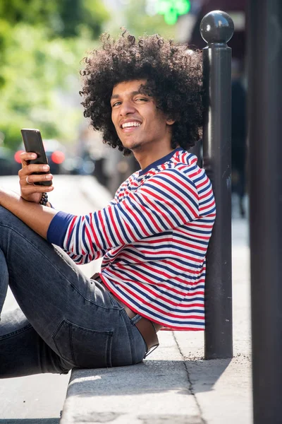 Retrato Lateral Del Joven Sonriente Sentado Piso Exterior Con Teléfono — Foto de Stock