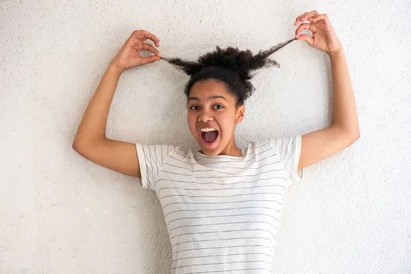 Retrato Alegre Jovem Afro Americana Puxando Cabelo Pelo Fundo Branco — Fotografia de Stock