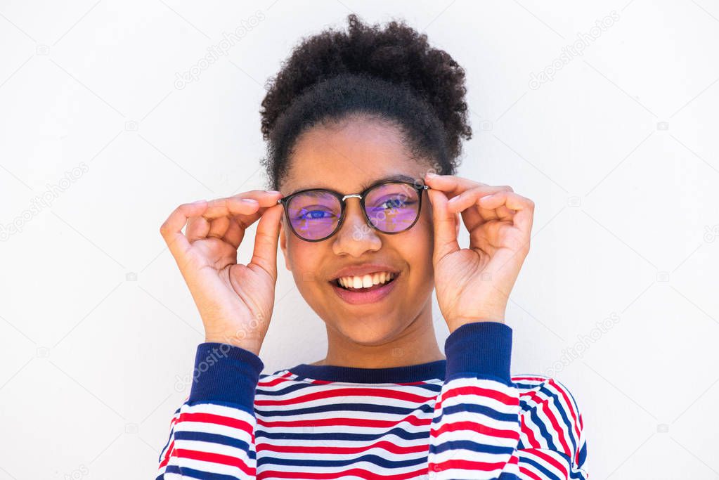 Close up portrait of young african american girl holding eyeglasses and smiling by white background