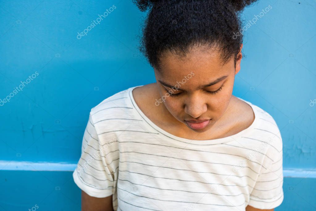 Close up portrait of sad young african american girl looking down