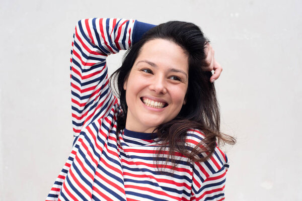 Close up portrait of young woman laughing with hand in hair