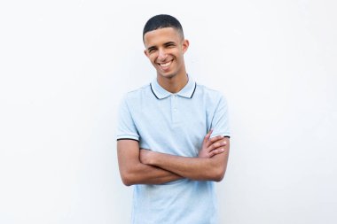 Genç Kuzey Afrikalı gülümseyen adam beyaz arka planda kollarını kavuşturmuş poz veriyor.