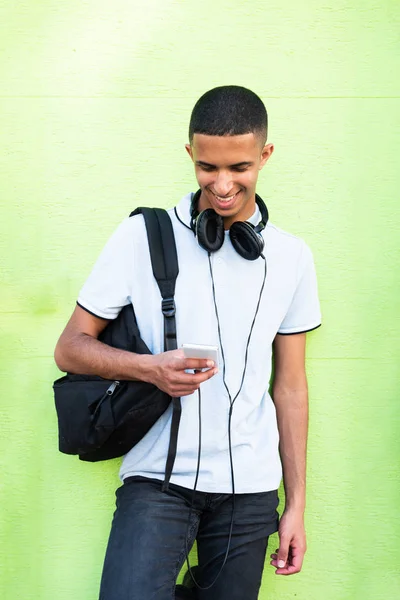 Portret Uśmiechnięty North African Student College Zielonym Tle Patrząc Telefon — Zdjęcie stockowe