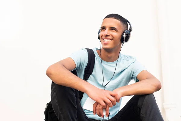 Portrait Happy Young North African Man Sitting White Wall Listening — Stock Photo, Image