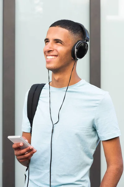 Portrait Smiling Young Man Holding Cellphone Bag Listening Music Headphones — Stock Photo, Image