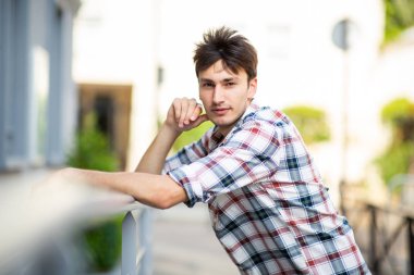 Dışarıya eğilmiş yakışıklı genç adamın yan portresi.