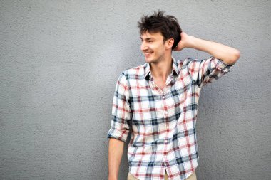 Elleri başının arkasında gülümseyen yakışıklı adamın portresi.