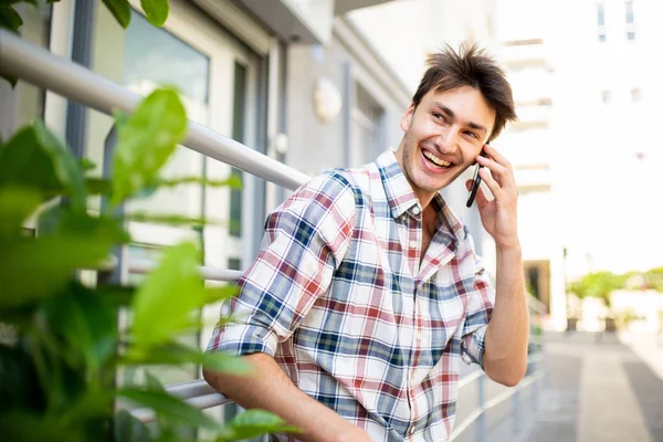 Boczny Portret Szczęśliwego Młodzieńca Rozmawiającego Telefonem Komórkowym Zewnątrz — Zdjęcie stockowe