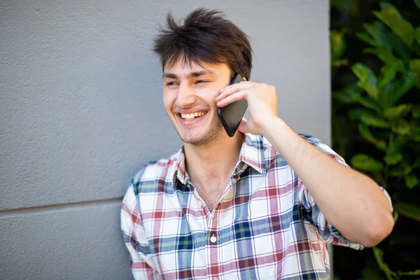Close Portrait Smiling Young Man Leaning Gray Wall Talking Mobile — Stock Photo, Image