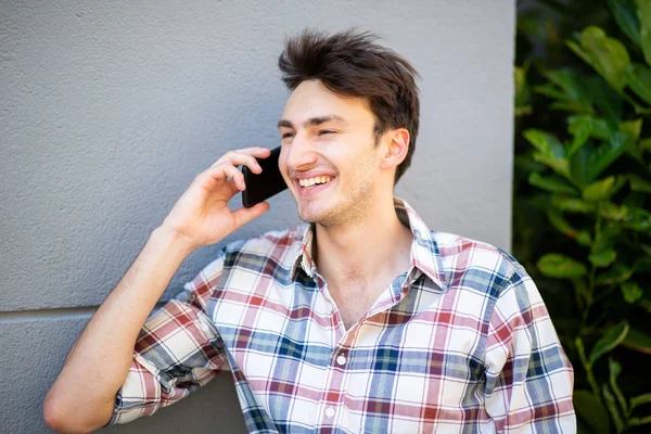 Feche Retrato Jovem Sorridente Encostado Parede Cinza Conversando Com Celular — Fotografia de Stock