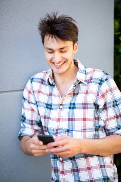 Портрет Красивого Молодого Человека Прислонившегося Стене Смотрящего Мобильный Телефон — стоковое фото