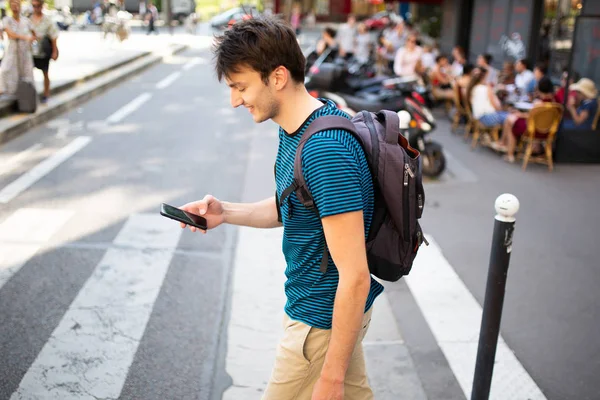 Portrét Mladého Muže Kráčejícího Taškou Mobilním Telefonem Ulici — Stock fotografie