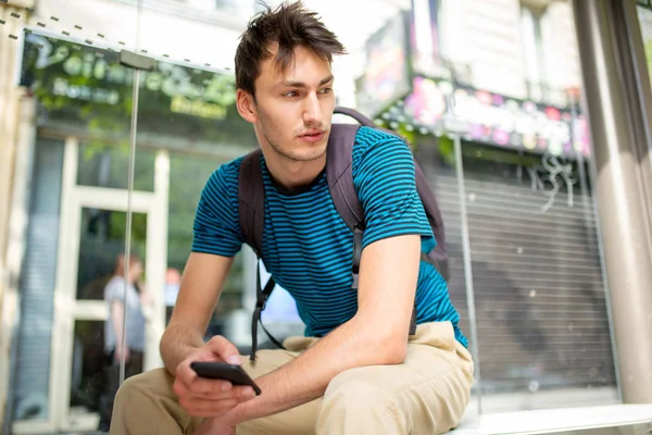 Portrait Jeune Homme Assis Arrêt Bus Avec Téléphone Portable Main — Photo