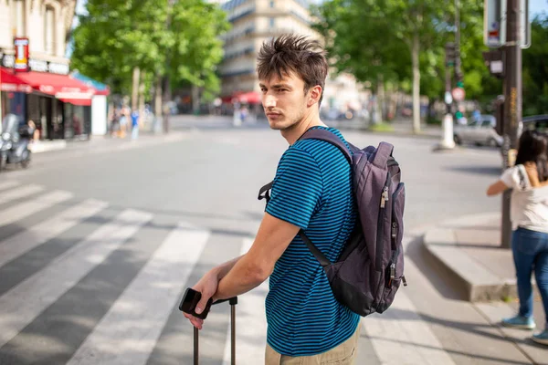 Portrait of travel man standing on city street with bag