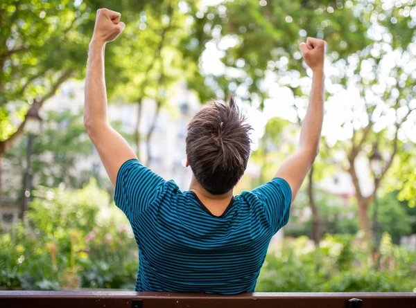 Portrait Young Man Sitting Park Bench Arms Raised — Stock Photo, Image