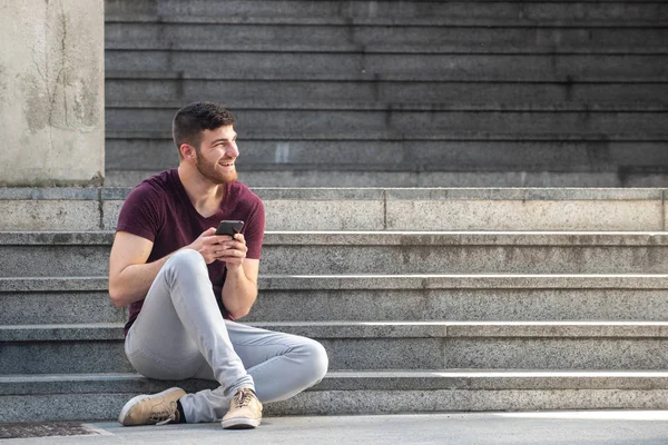 Merdivenlerde Cep Telefonuyla Oturan Yakışıklı Bir Gencin Vücut Portresi — Stok fotoğraf