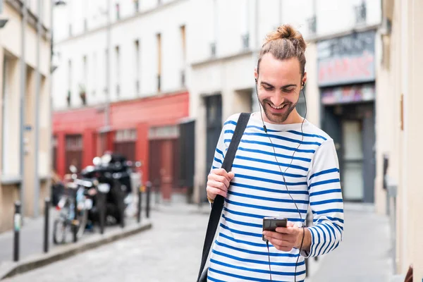 Şehirde Cep Telefonu Kulaklıkla Müzik Dinleyen Mutlu Genç Adamın Portresi — Stok fotoğraf