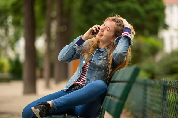 Бічний Портрет Щасливої Молодої Жінки Сидить Лавці Парку Розмовляє Мобільним — стокове фото
