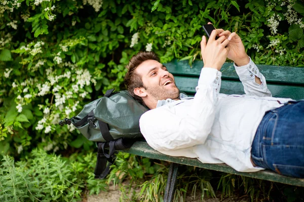 Портрет Счастливого Пожилого Мужчины Лежащего Скамейке Парке Смотрящего Мобильный Телефон — стоковое фото