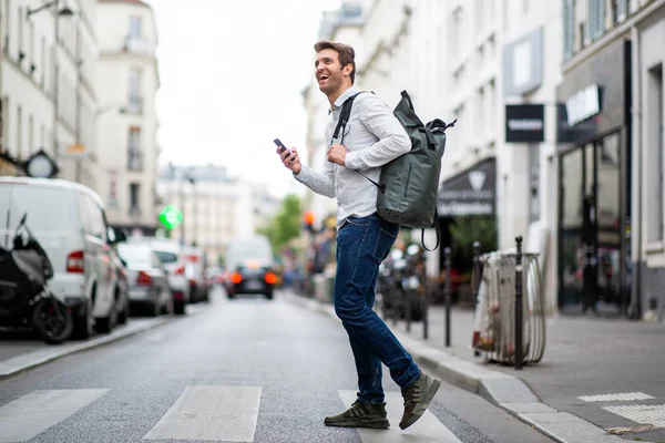 携帯電話で通りを横断幸せな旅行男の完全な長さ側の肖像画 — ストック写真