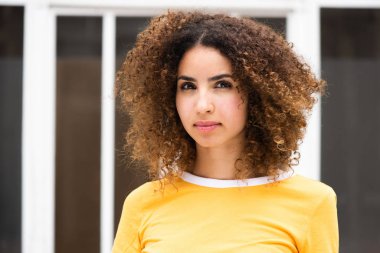 Dışarıda kıvırcık saçlı, ciddi bir Afro-Amerikan kadının yatay portresini kapat.