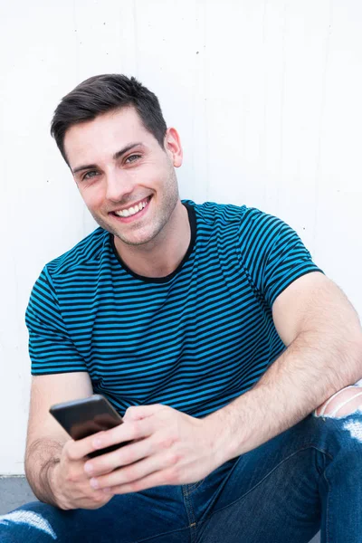 Portrait Smiling Young Man Sitting Holding Mobile Phone White Background — Stock Photo, Image