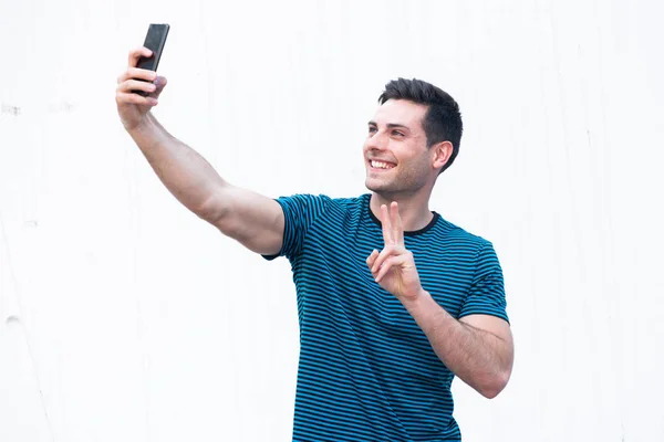 Portrét Pohledného Mladého Muže Při Selfie Mobilním Telefonem Bílém Pozadí — Stock fotografie