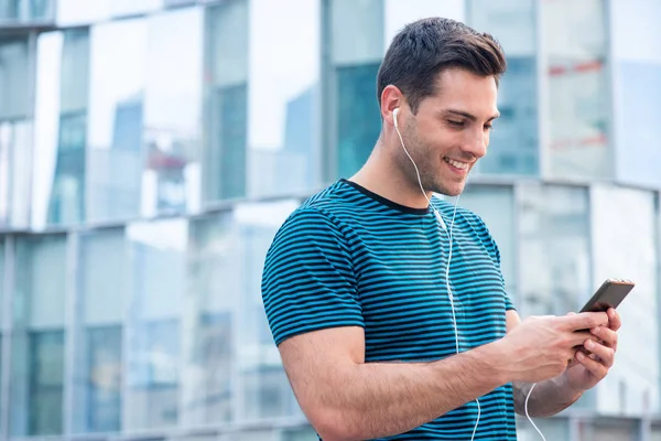 Sidoporträtt Leende Ung Man Lyssnar Musik Med Mobiltelefon Och Hörlurar — Stockfoto