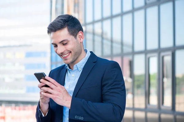 Close Portret Uśmiechniętego Biznesmena Patrząc Telefon Komórkowy Mieście — Zdjęcie stockowe