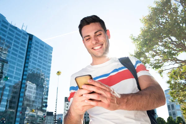 Portrait Jeune Homme Souriant Marchant Ville Regardant Téléphone Mobile — Photo