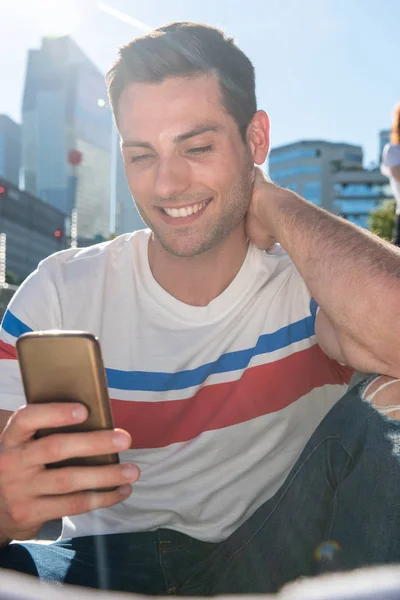 Retrato Cerca Joven Sonriente Sentado Ciudad Mirando Teléfono Móvil — Foto de Stock