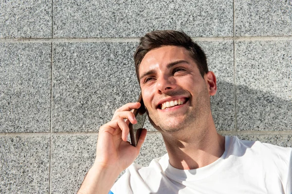 Закрыть Портрет Счастливого Молодого Человека Разговаривающего Телефоном Серой Стены — стоковое фото
