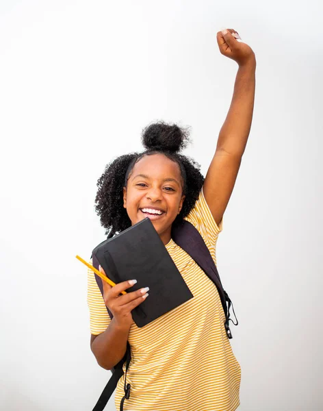 ポートレート幸せなアフリカ系アメリカ人ティーン女の子学生応援とともに本とバッグアーム持ち上げました隔離された白の背景 — ストック写真