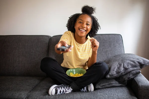 Portrait Happy African American Teenage Girl Sitting Sofa Pointing Remote — Stock Photo, Image
