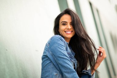 Close up side portrait beautiful young hispanic woman smiling with hand in hair